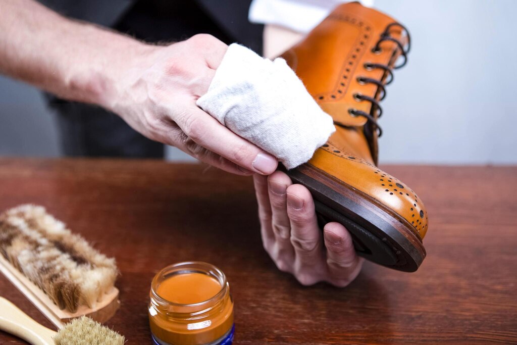 Close Up of Mans Hands Cleaning Luxury Calf Leather Brogues with Special Cloth. 
